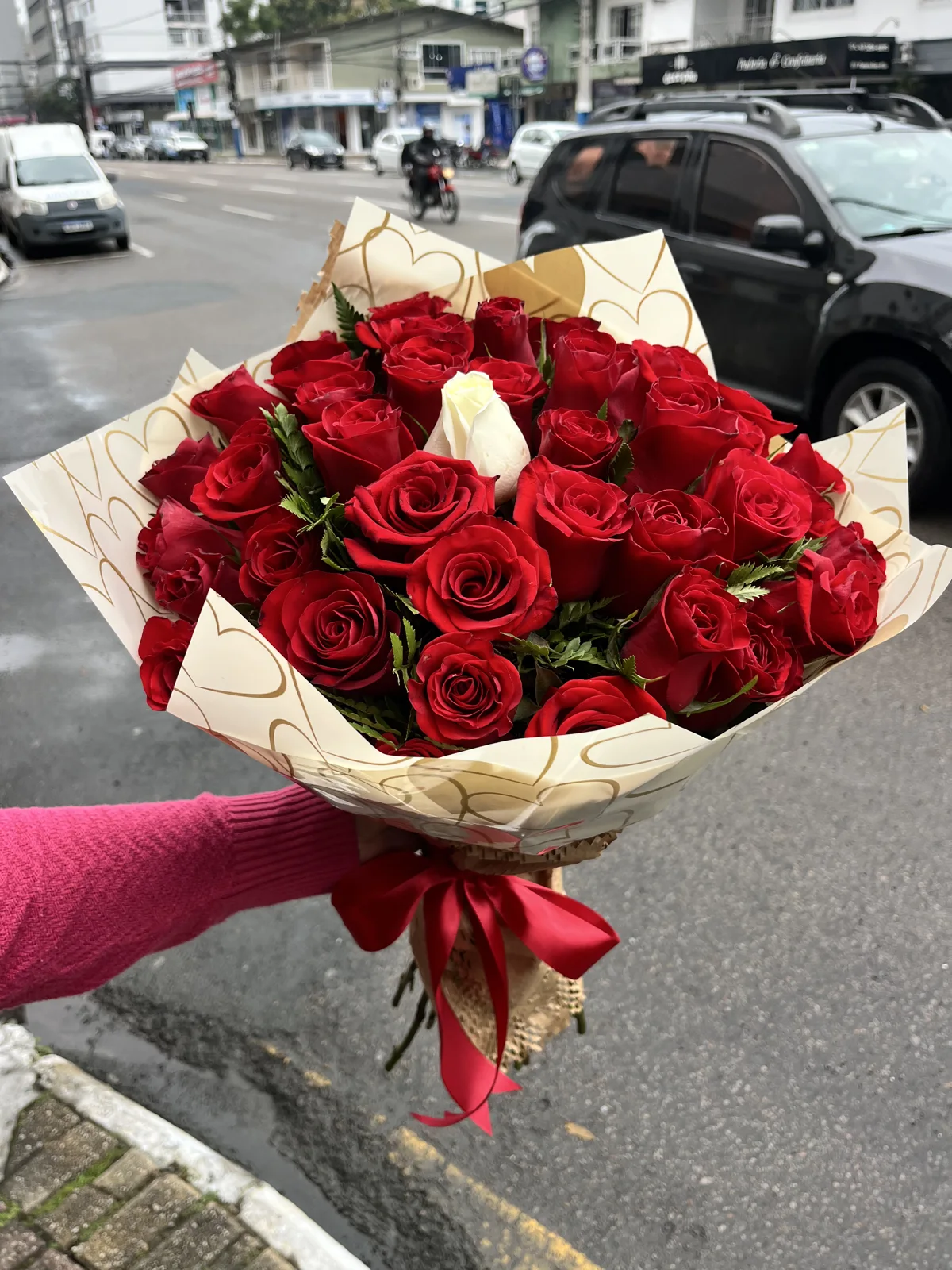 Buquê de rosas vermelhas com folhagens e laço vermelho